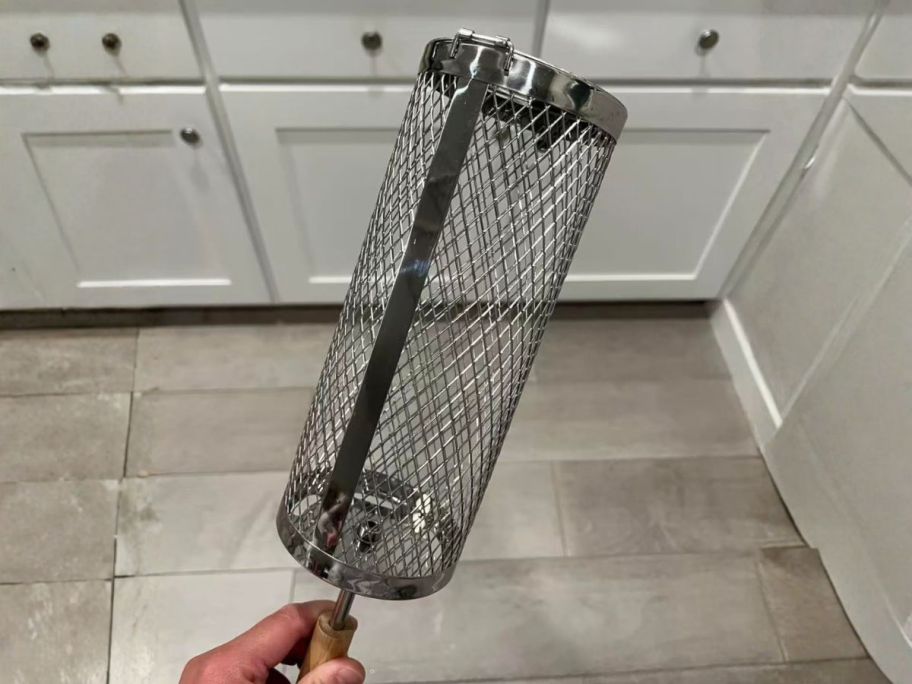 hand holding Basinel Rolling Grill Basket in kitchen