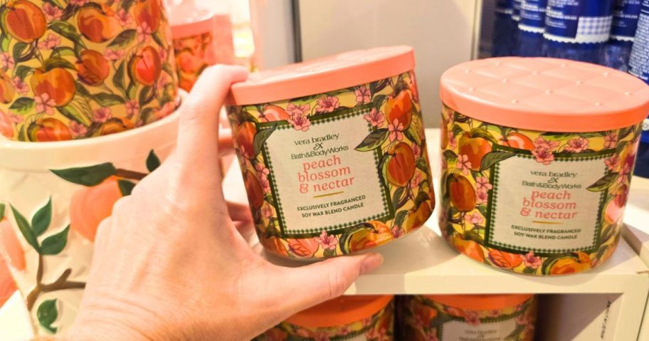 Hand touching a Bath & Body Works Vera Bradley Candle
