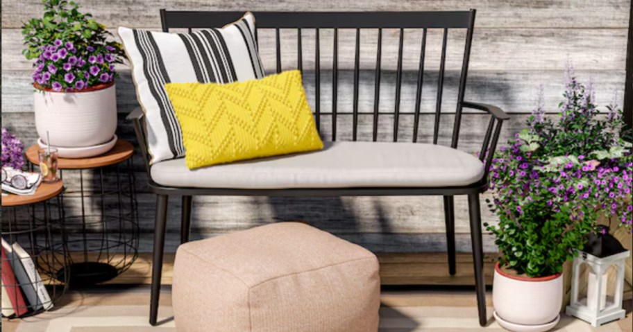 Black aluminum bench with gray cushion outside on patio