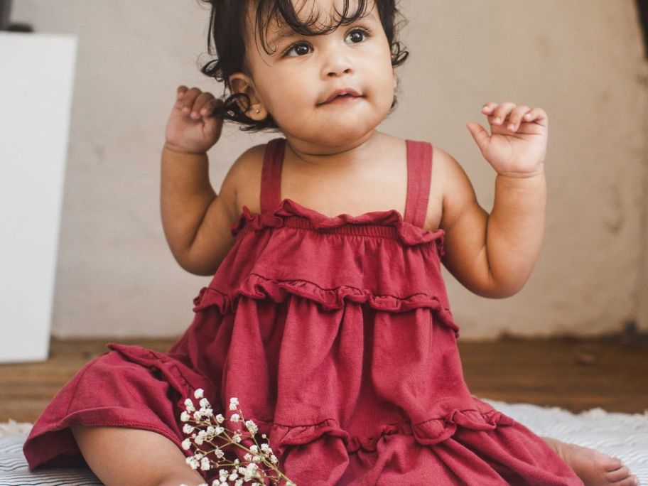 toddler girl wearing a red burt's bees dress