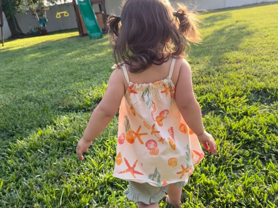 فتاة صغيرة ترتدي زي Burt's Bees Baby المكون من قطعتين مع أصداف بحرية