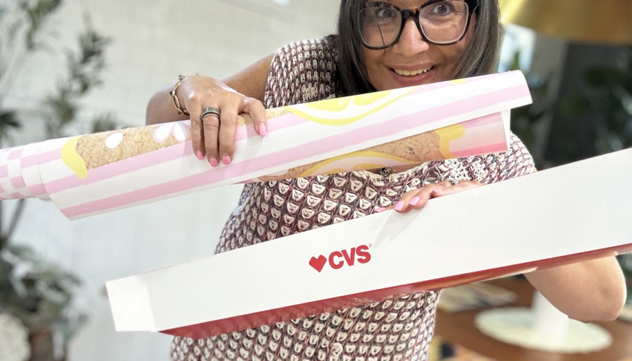 woman holding rolled banner and cvs photo box