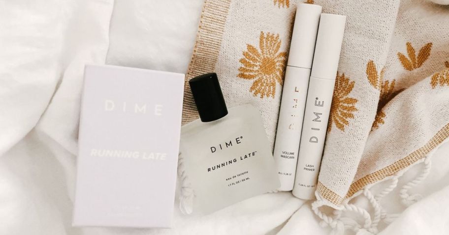 Dime beauty Perfume, Mascara and Lash Pimer on a bed