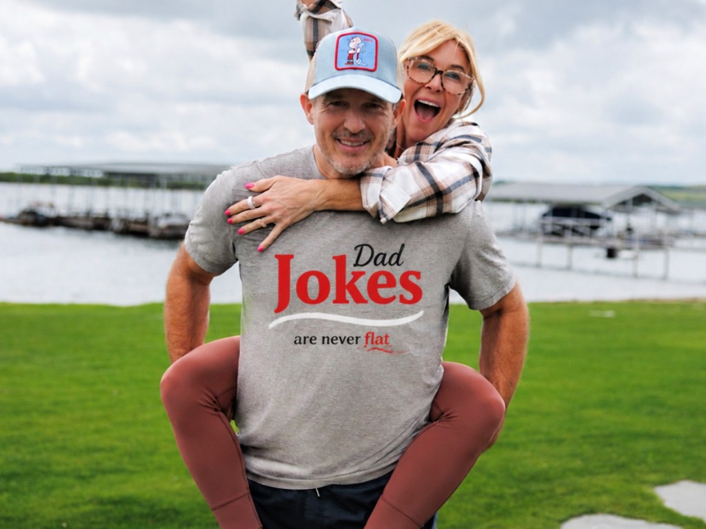 Man wearing gray dad jokes T-shirt with woman on piggy back