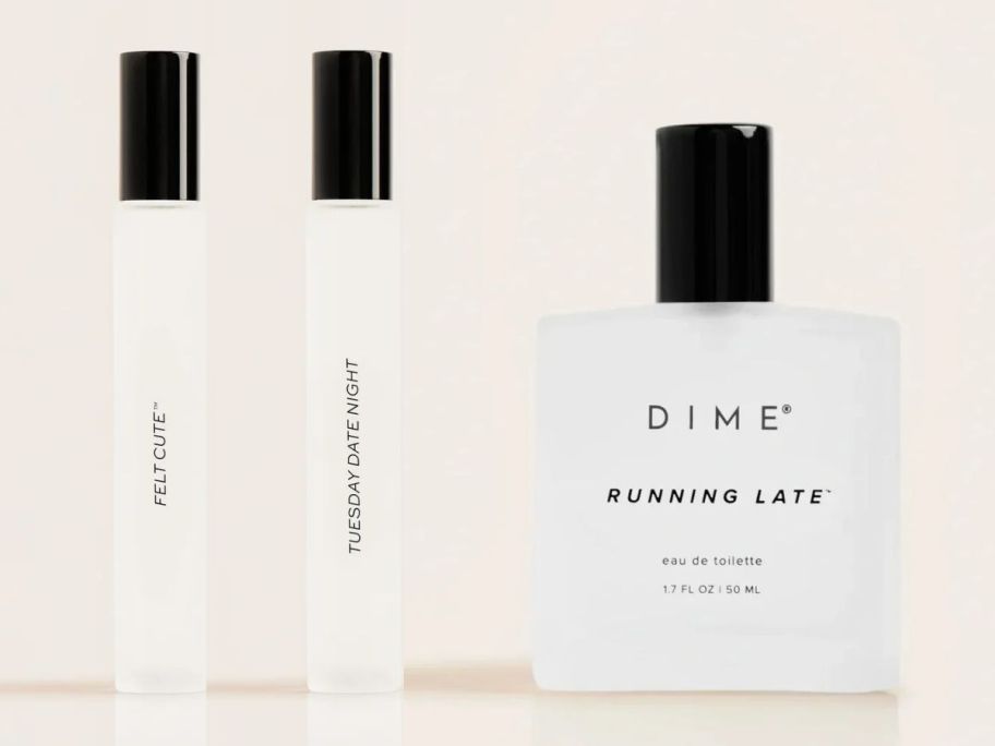 Stock images of two DIME Beauty Perfume Rollerballs and a full-size bottle of Perfume