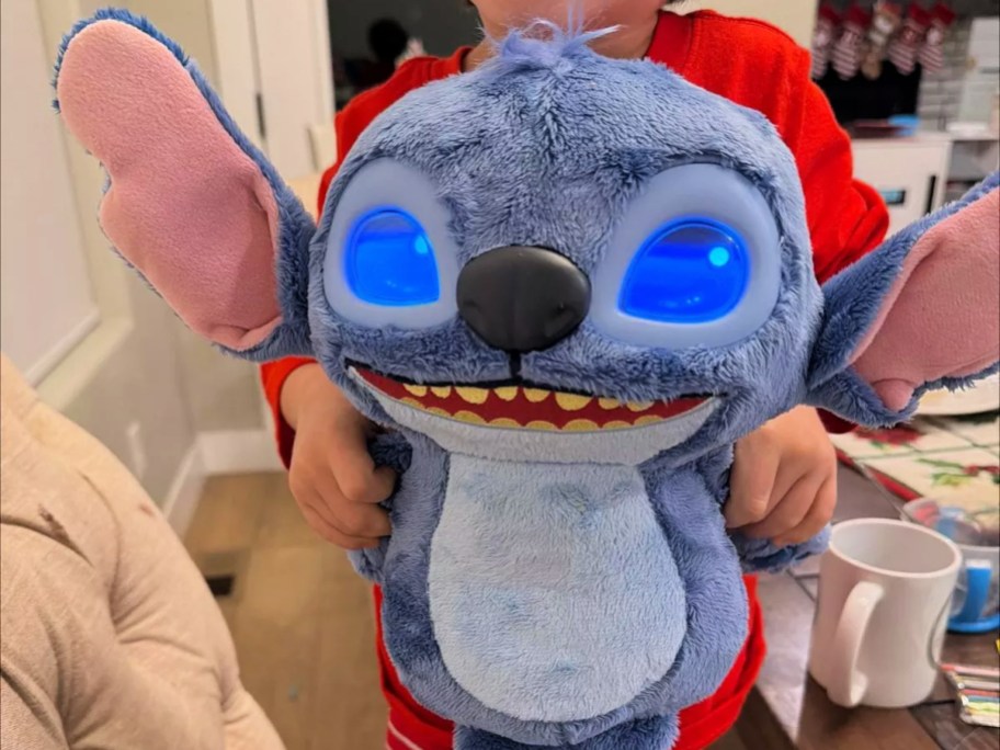 child holding a Disney Many Moods Stitch Plush toy