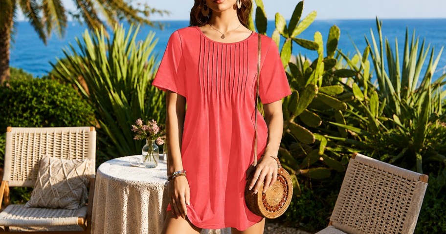 woman in a pink dress, outdoor cafe by the beach behind her