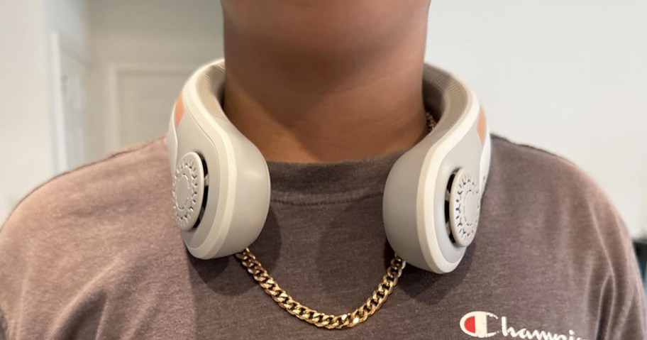 person wearing a light grey neck fan and gold chain