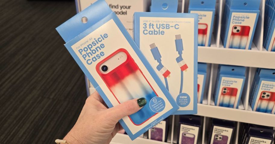 hand holding GEMS iPhone Air Popsicle Phone Case and Figural Popsicle USB-C Cable boxes in store
