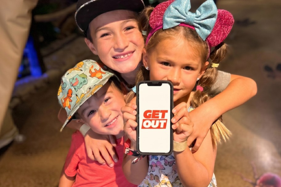 3 kids posing and holding up a phone with the GetOut logo featured