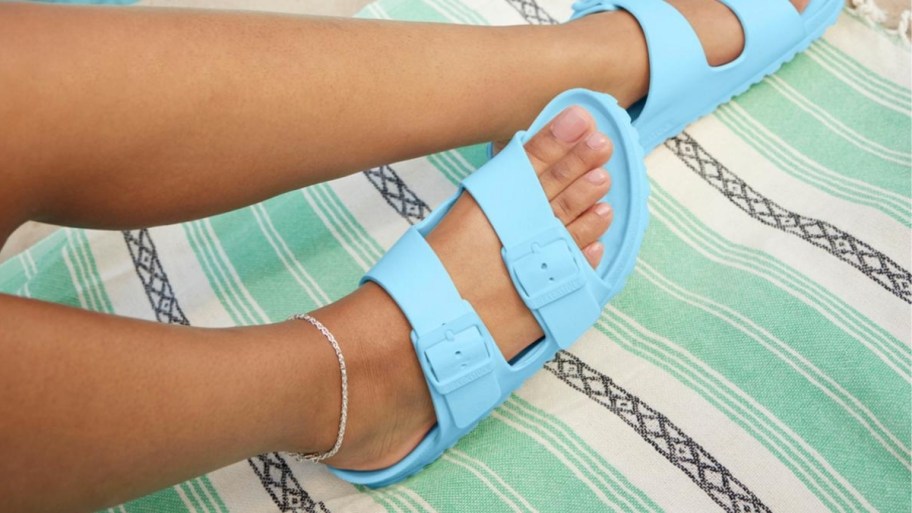 a woman wearing a pair of sky blue eva footbed sandals