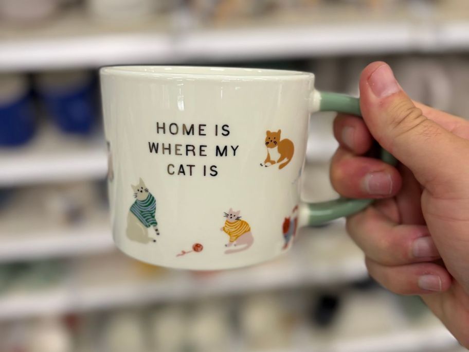 Home Is Where My Cat Is Mug in hand in store