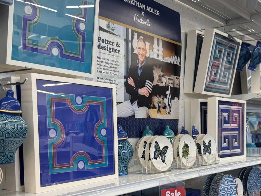 jonathan adler wall art and plates on a store shelf