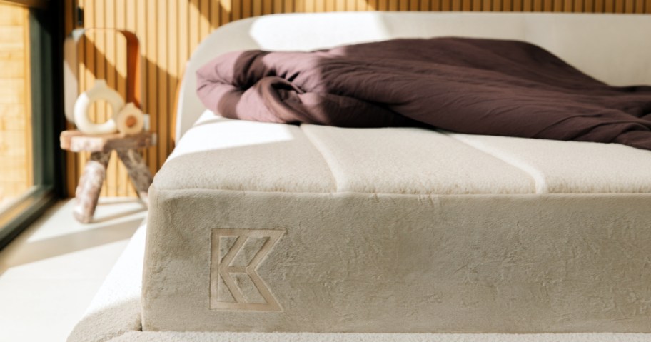The cozy, sunny bedroom has a beige mattress. 