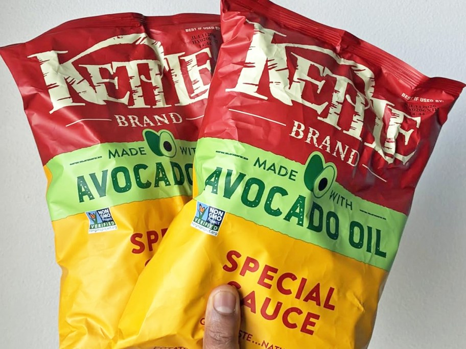 hand holding up two bags of Kettle Special Sauce Chips