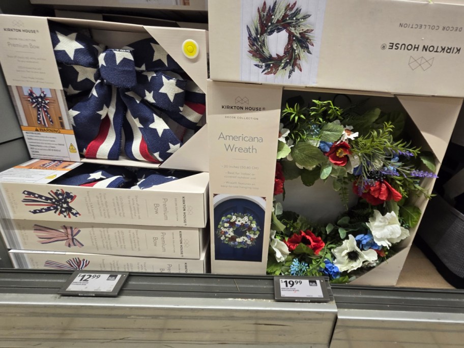 Decorative Americana-themed items on a store shelf, featuring a star-spangled bow and a red, white, and blue floral wreath.