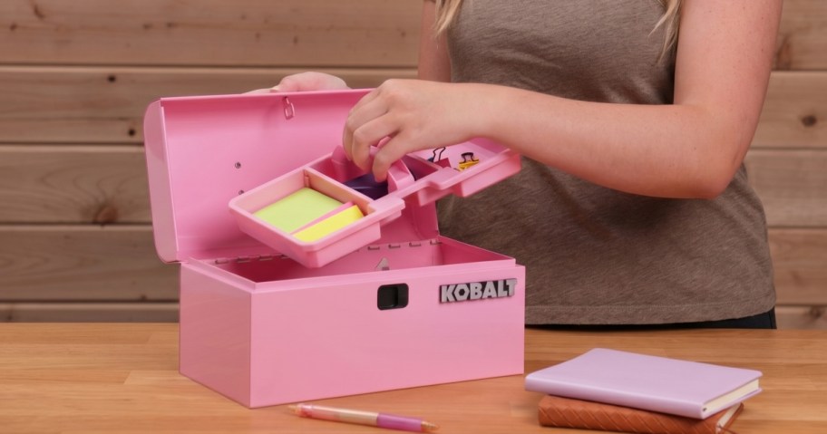 Woman pulling a tray from a pink mini toolbox