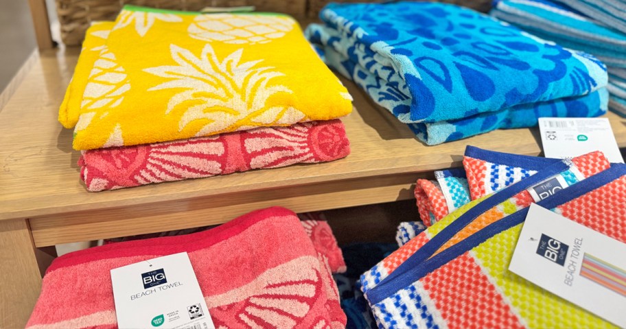 colorful folded beach towels on store display table
