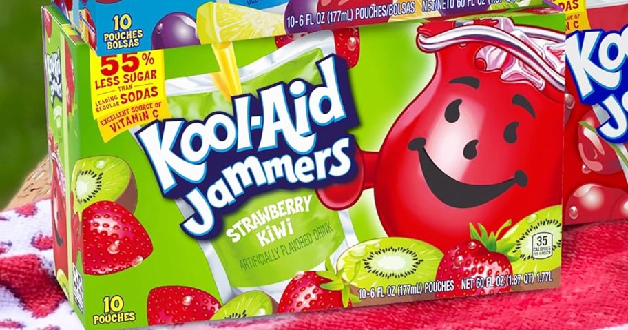 green box of strawberry kiwi Kool-Aid Jammers on a beach towel