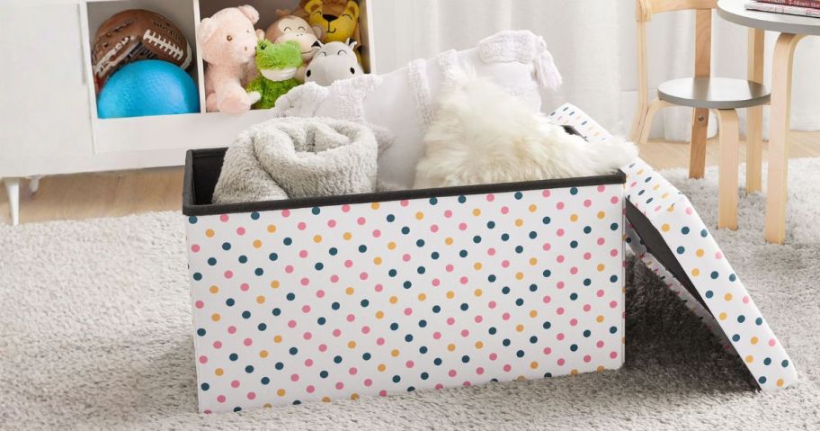 Kvell Foldable Child's Collapsible Toy Storage Chest with blankets in it in toy room