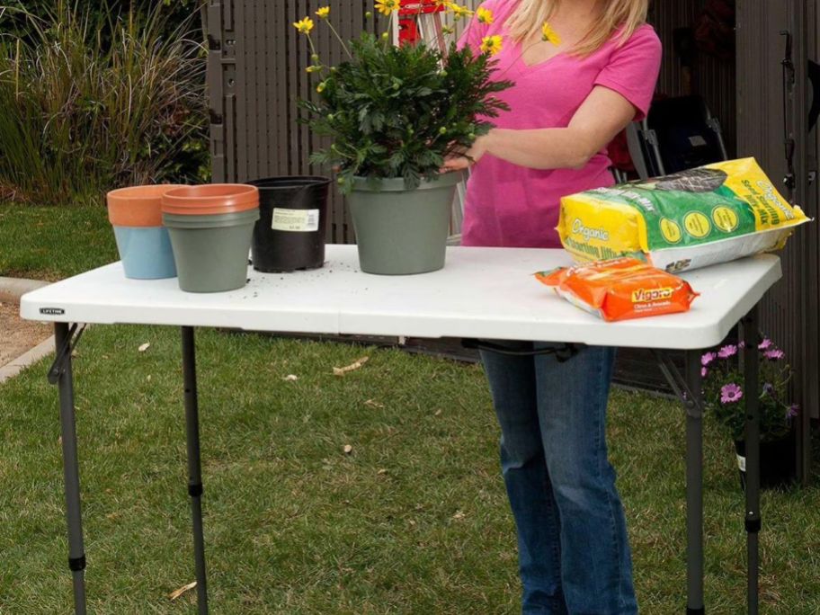 woman potting plants on Lifetime 4' Commercial Grade Adjustable Fold-in-Half Table