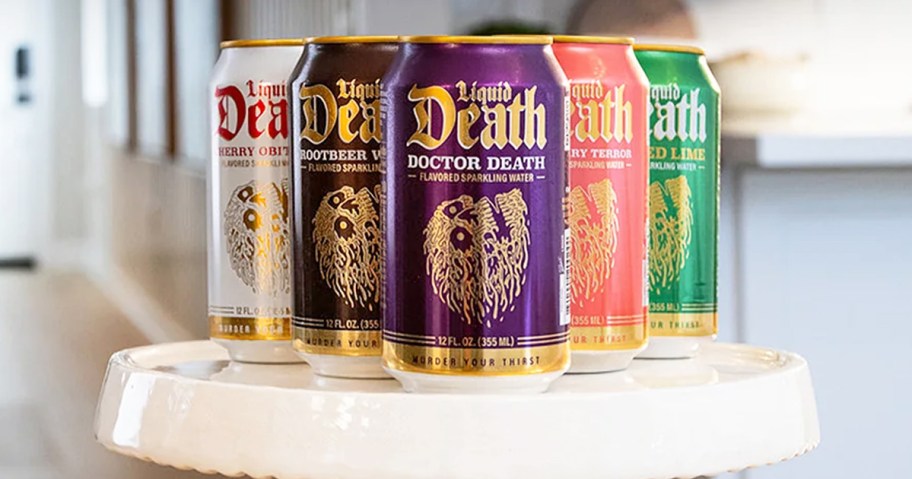 cans of Liquid Death on a white cake stand