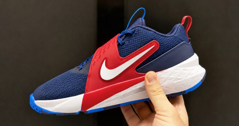 hand holding a navy blue and red nike sneaker