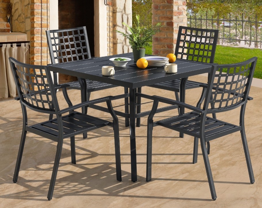 a five piece iron table and chairs on a patio