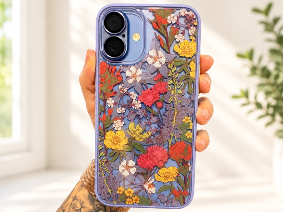Hand holding a phone with a floral case