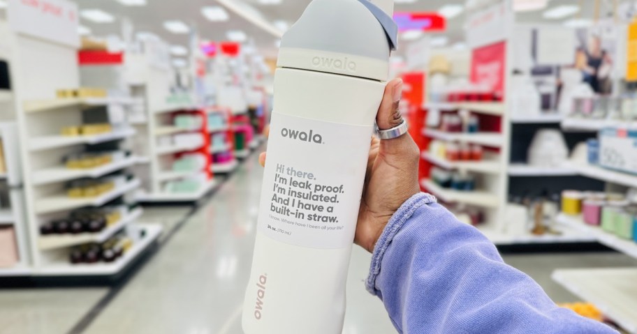 hand holding up a white owala water bottle tumbler in store