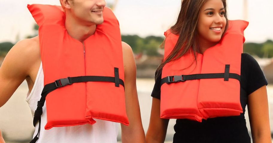 a man and a woman wearing Ozark Trail Unisex Adult Type II PFD Life Jackets