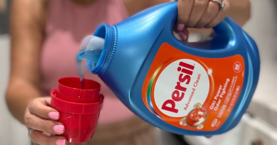 woman pouring Persil laundry detergent from the bottle into the cap