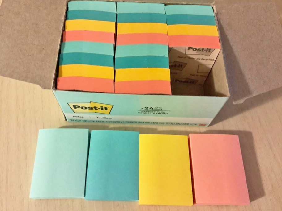 colorful post-it note pads on table and in box