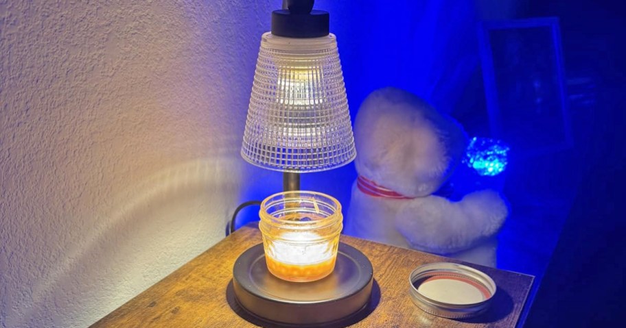 candle warmer lamp on a side table with blue nightlight in background