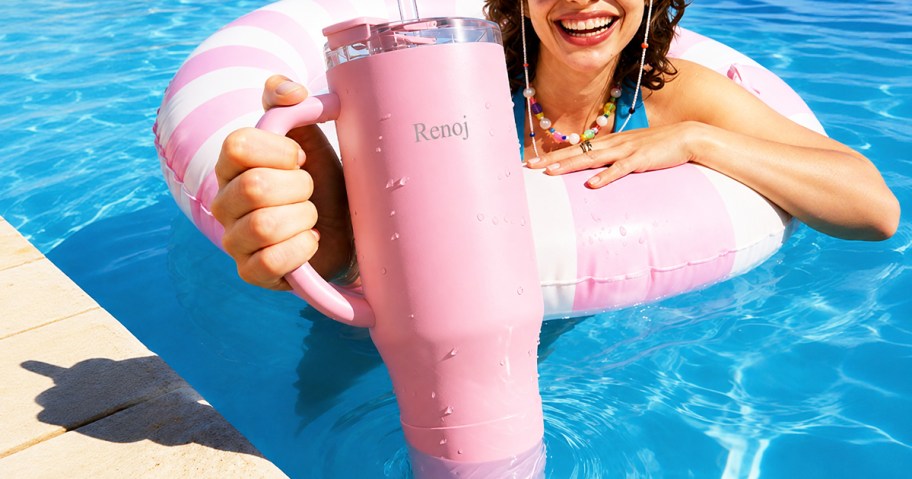 woman in a pink pool float holding a pink tumbler