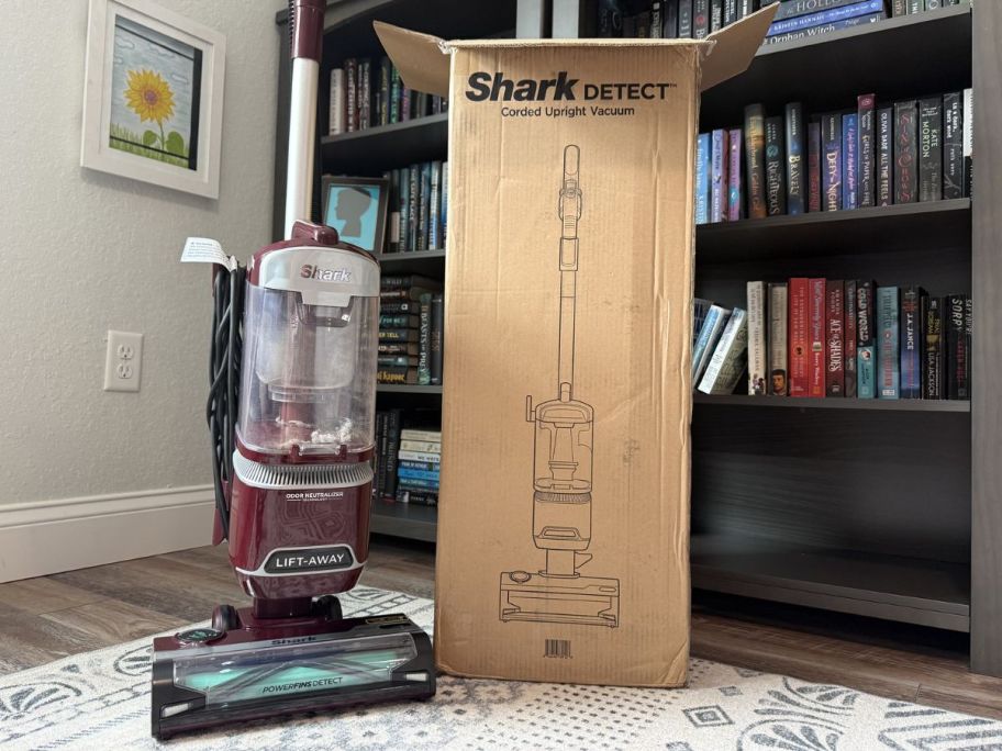 Shark lift away vacuum next to its box on top of a rug