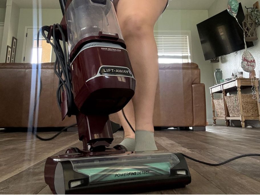 woman using a Shark lift away on wooden floors 