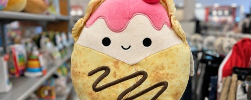 hand holding up strawberry crepe squishmallow in store