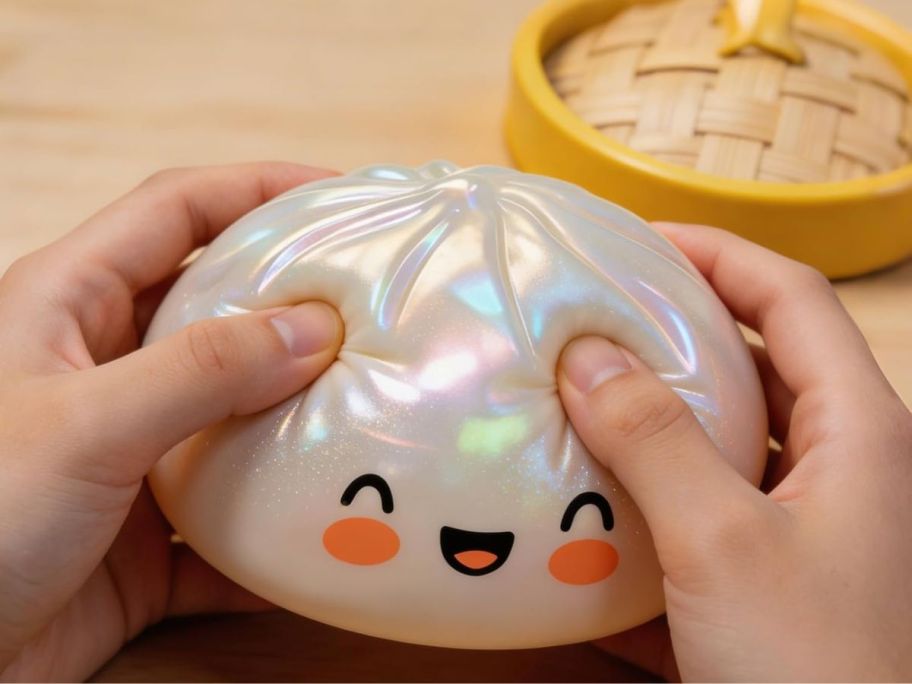 Hand playing with a glitetr squishy dumpling