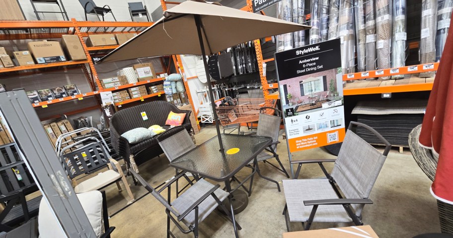 outdoor table, chairs, and umbrella on display in store