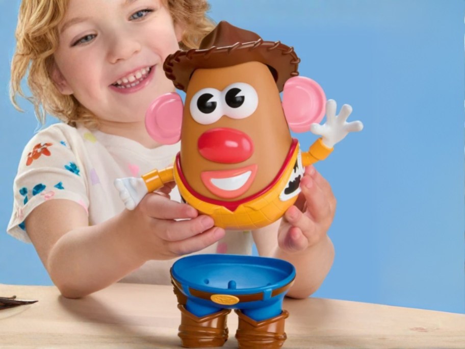 a little girl playing with a Woody Toy Story Mr. Potato Head toy