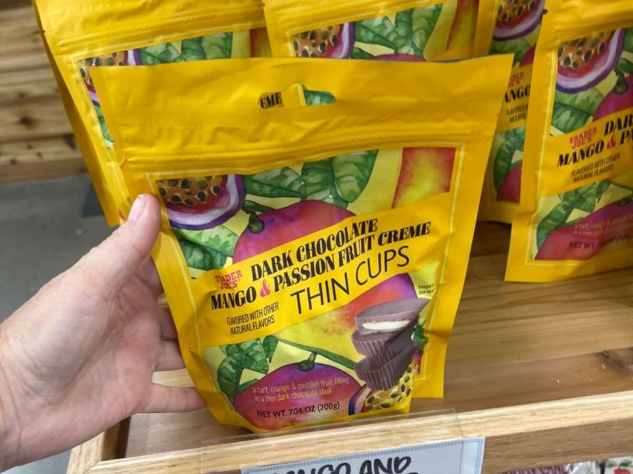 Trader Joe's Dark Chocolate Mango & Passion Fruit Creme Thin Cups in hand in store