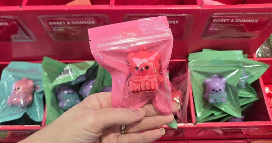 Hand holding a pack with a Sweet & Shimmer bear lip balm from ULTA