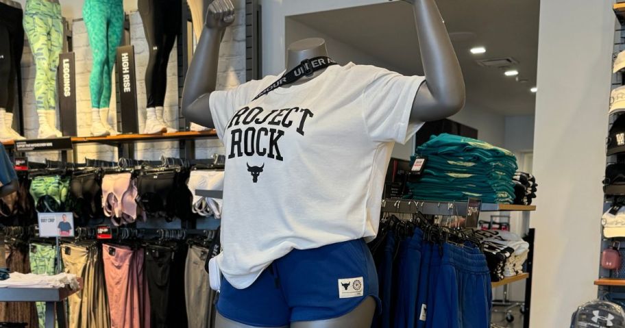 A mannequin at an Under Armour store wearing a project rock tee and shorts