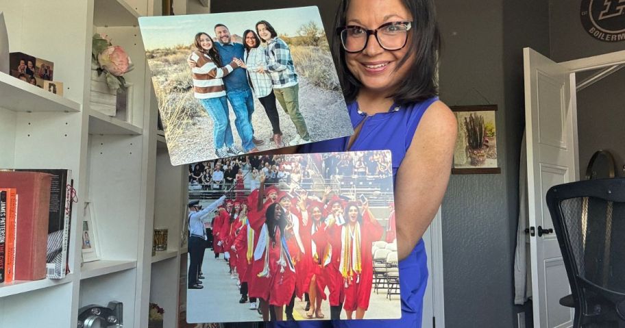 Woman holding two metal photo prints from Walgreens fearuring a family of four and teens at a graduation wearing red caps and gowns