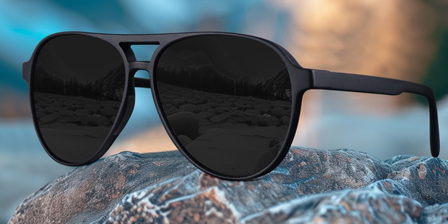 black aviator sunglasses on rock 