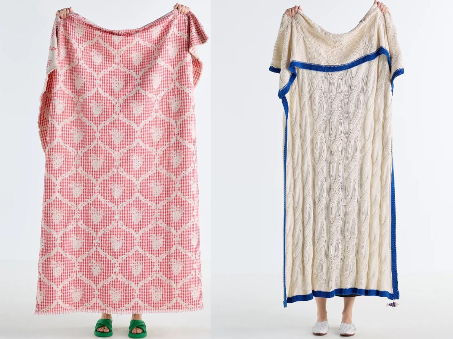 women holding up red and white blankets 