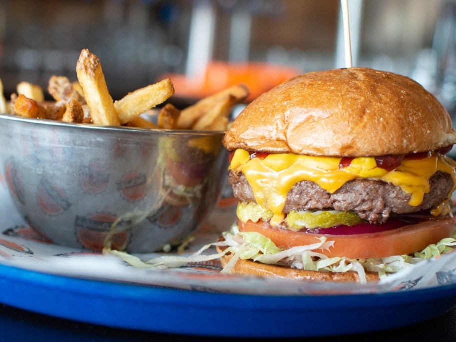 cheeseburger next to silver bowl of fries