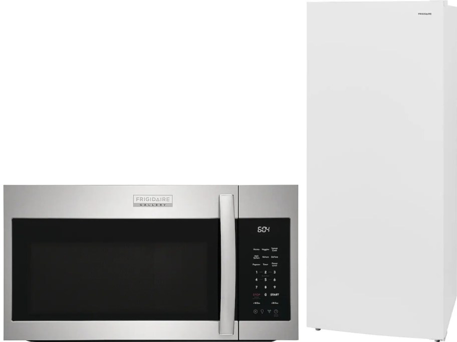 Stainless steel microwave with digital display and keypad next to a tall, sleek white freezer. 