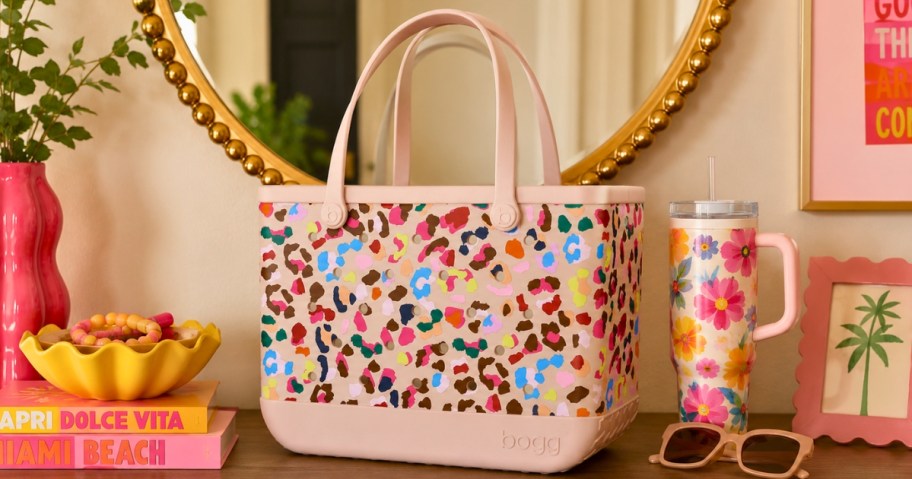 a pink Bogg Bag with bright color animal print on an entryway table